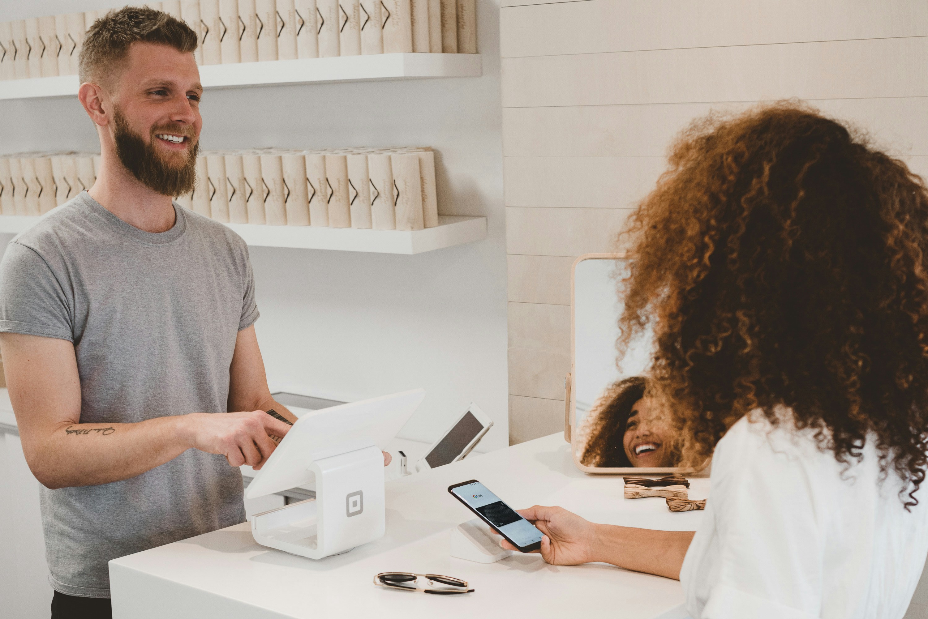 Guest completing a purchase at a counter — converting interest into a booking