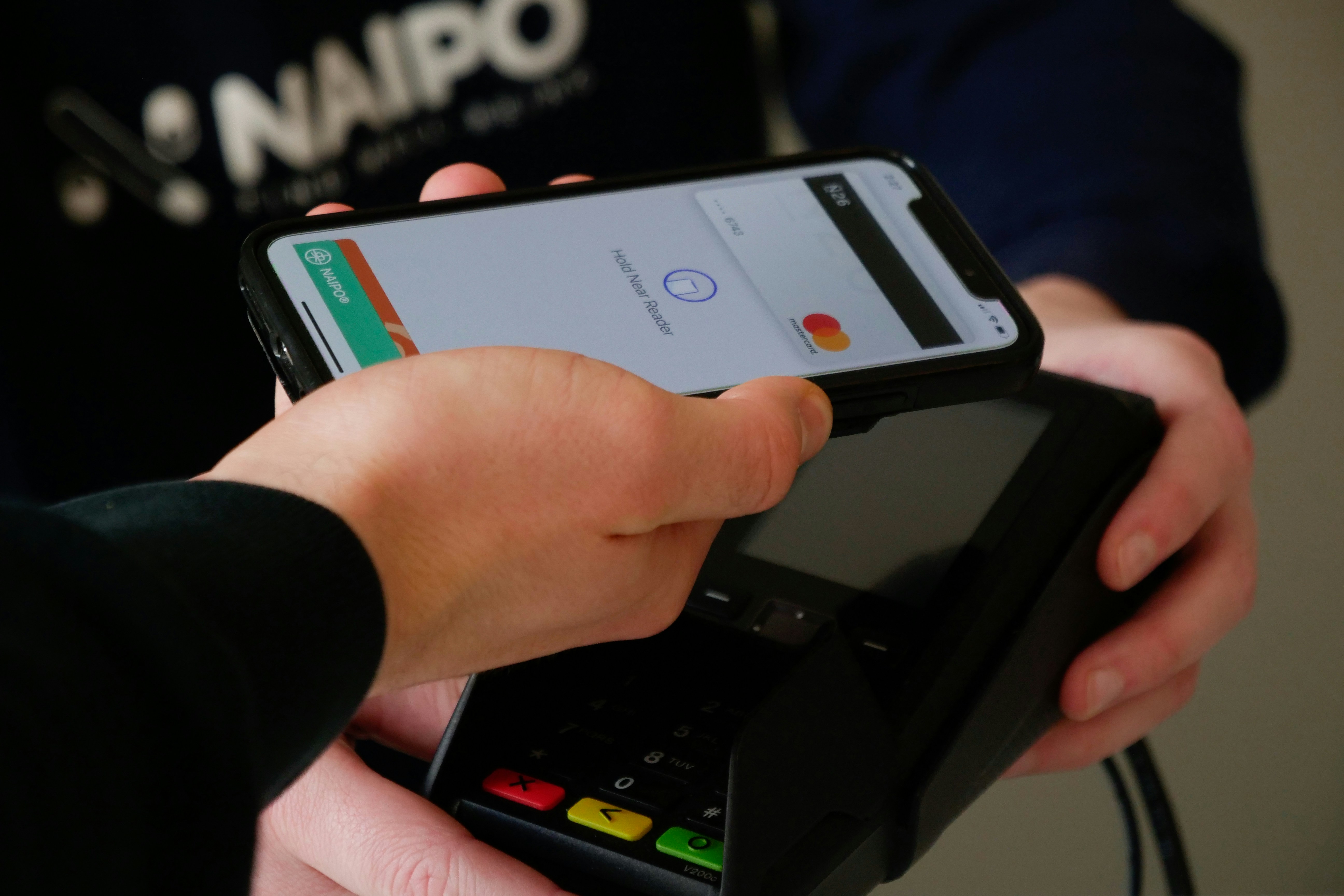 Guest paying with a card and smartphone at checkout